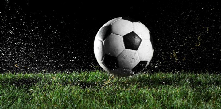 Football ball on the field wuring rainy night